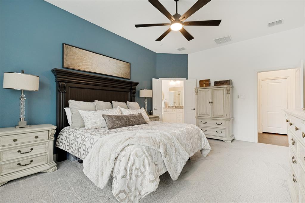 229 Savannah Lane Oak Point, TX 75068 - Photo 13 of 26 a bedroom with a bed and a chandelier