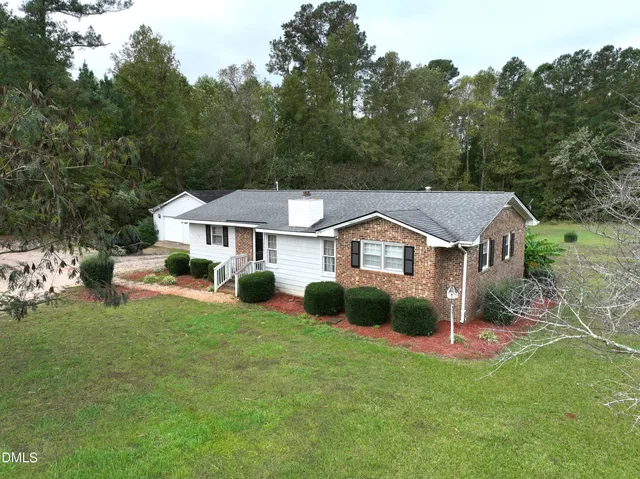 a aerial view of a house with a big yard and large trees