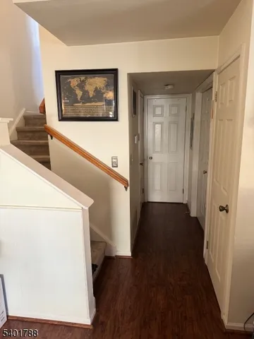 a view of a hallway with wooden floor and stairs
