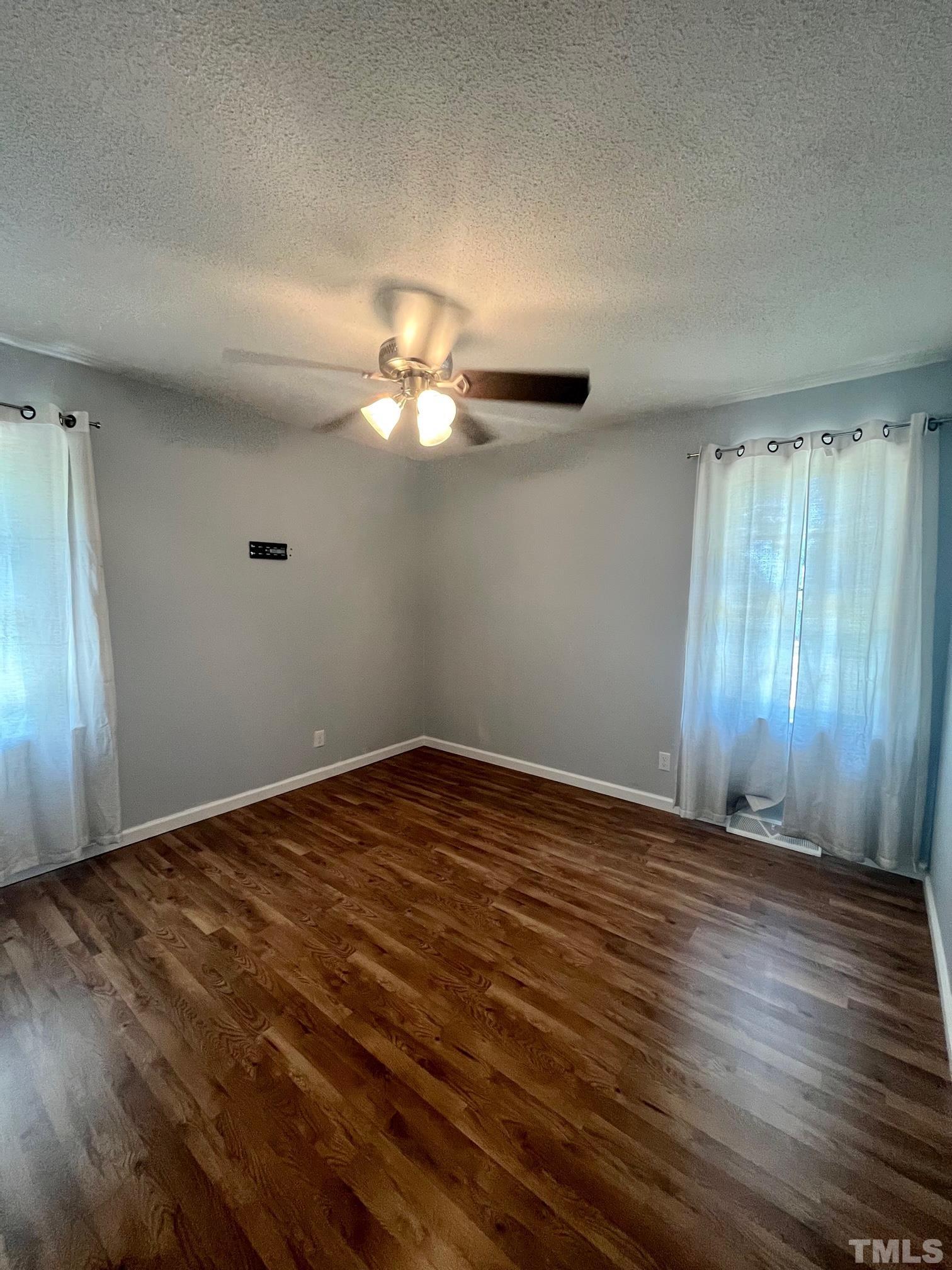 2342 Mitchell Road Angier, NC 27501 - Photo 5 of 10 an empty room with wooden floor fan and window