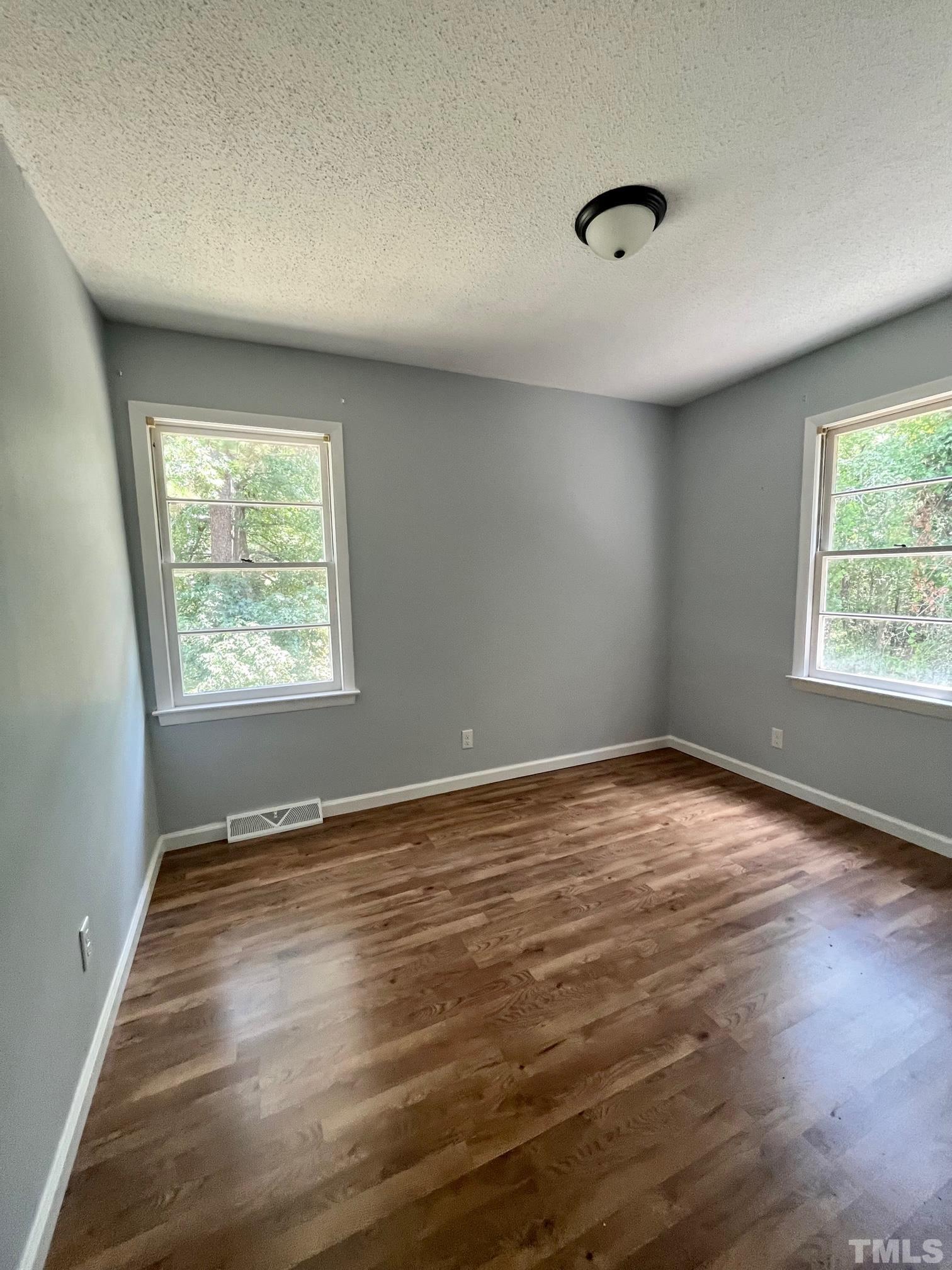 2342 Mitchell Road Angier, NC 27501 - Photo 6 of 10 an empty room with wooden floor and windows