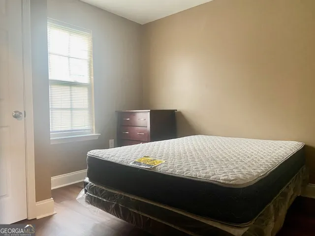 a bed sitting in a bedroom next to a window
