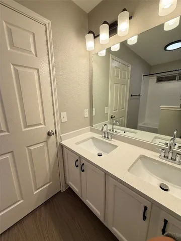 a bathroom with a double vanity sink and a mirror