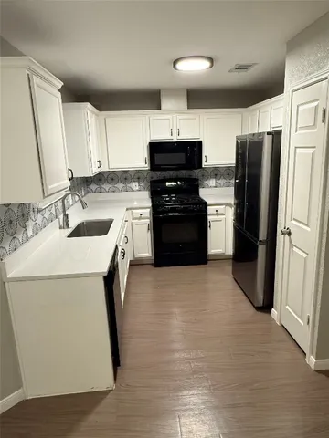 a kitchen with a sink appliances and cabinets