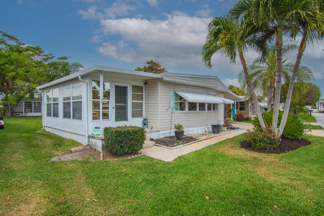 a view of a house with a yard and sitting area