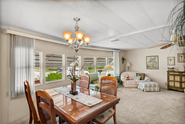 a view of a dining room with furniture a chandelier and window