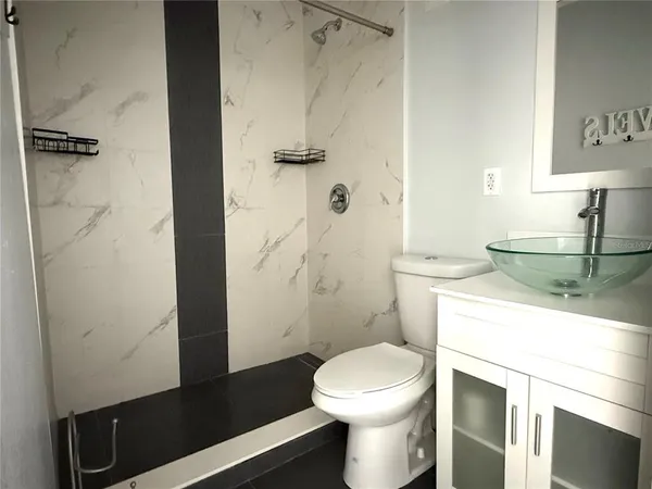 a bathroom with a sink a toilet and shower