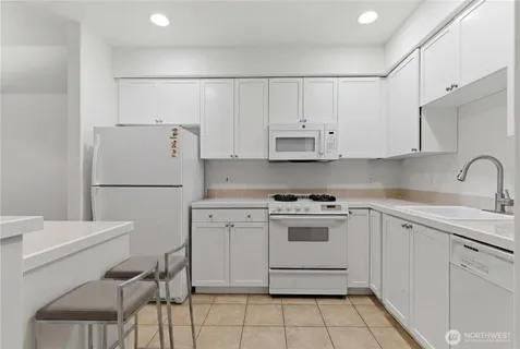 a kitchen with white cabinets and white appliances
