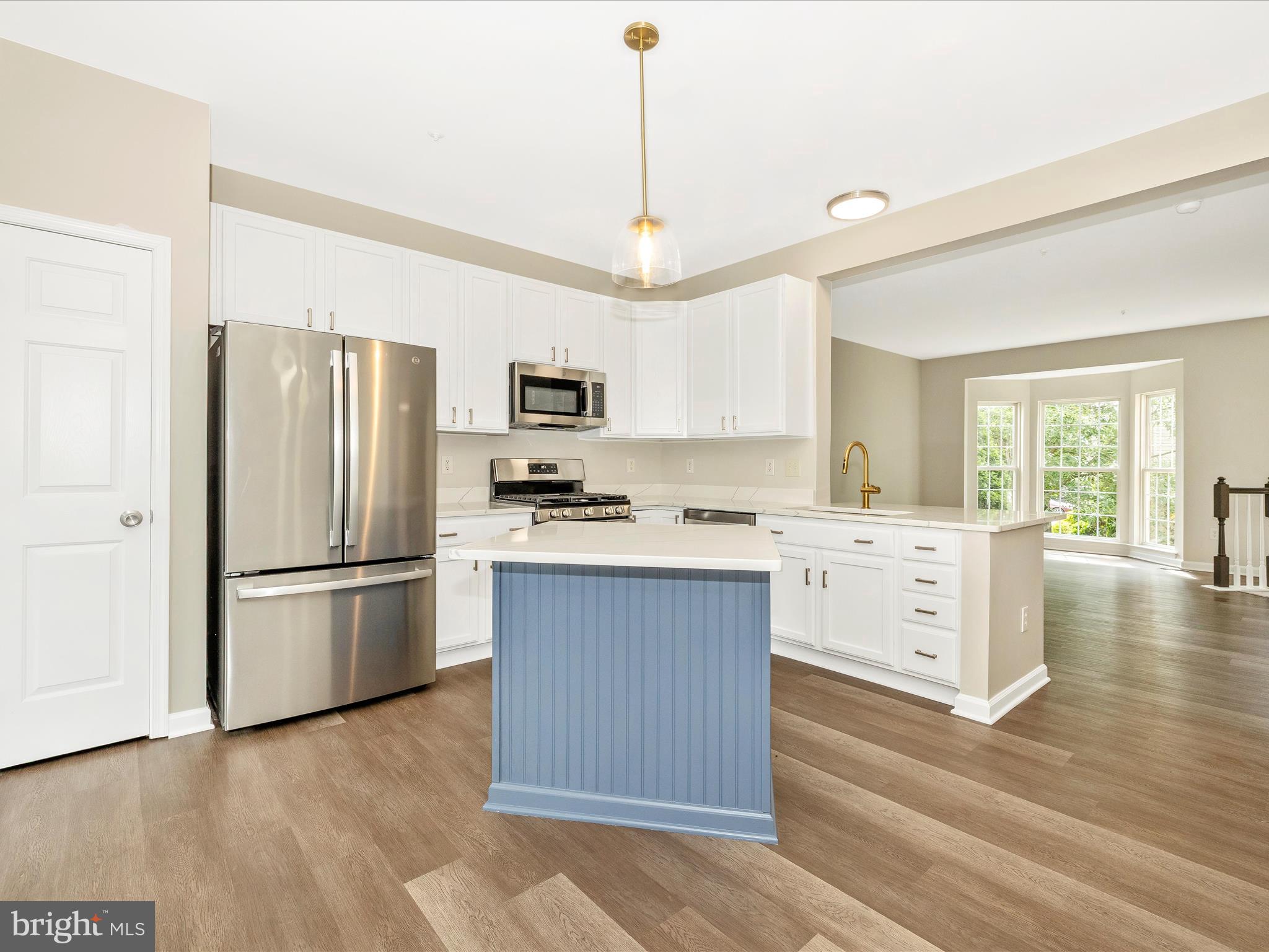 5534 Upshur Square Frederick, MD 21703 - Photo 14 of 46 a kitchen with stainless steel appliances a refrigerator stove microwave and cabinets