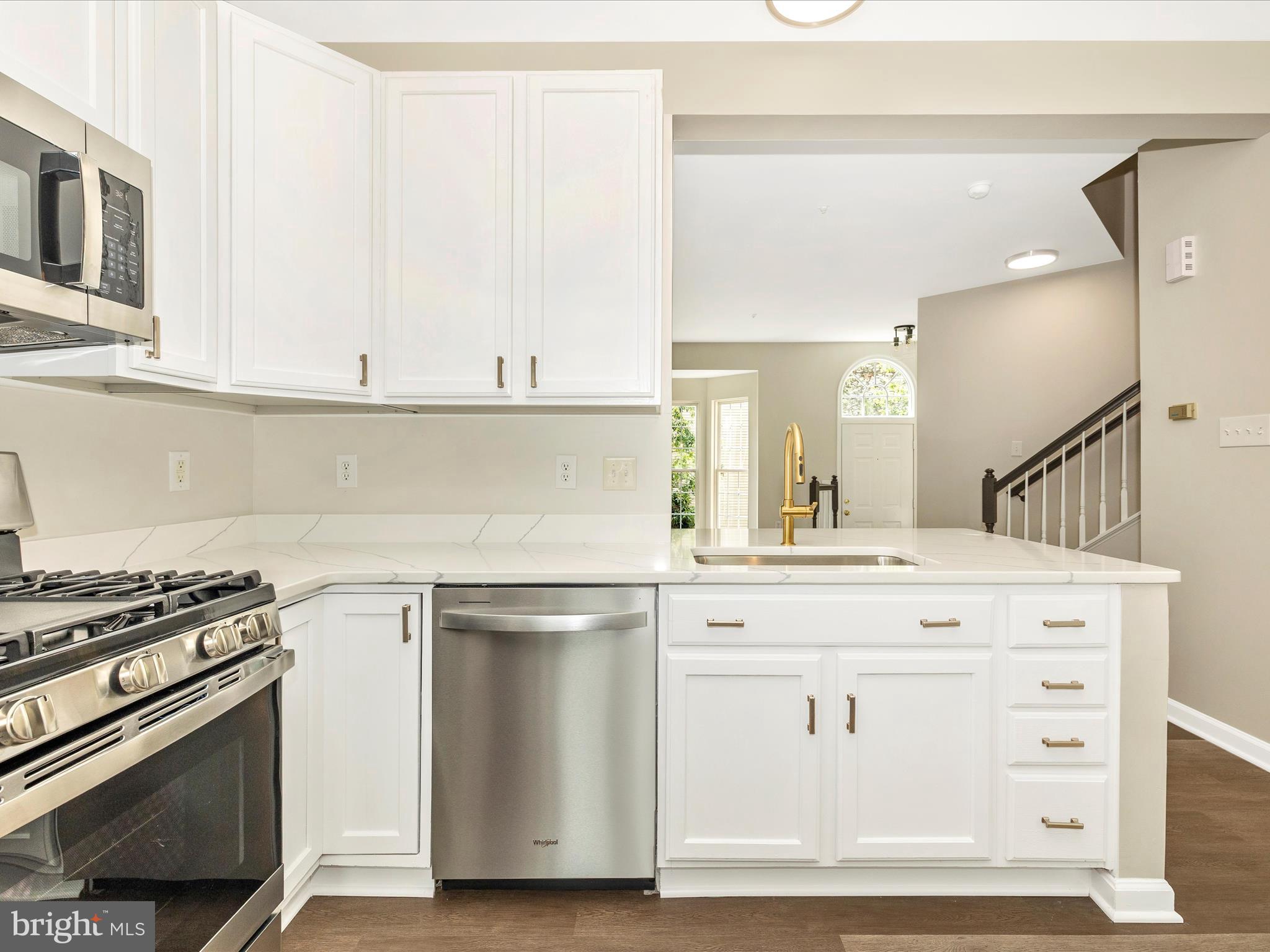 5534 Upshur Square Frederick, MD 21703 - Photo 16 of 46 a kitchen with cabinets appliances and wooden floor