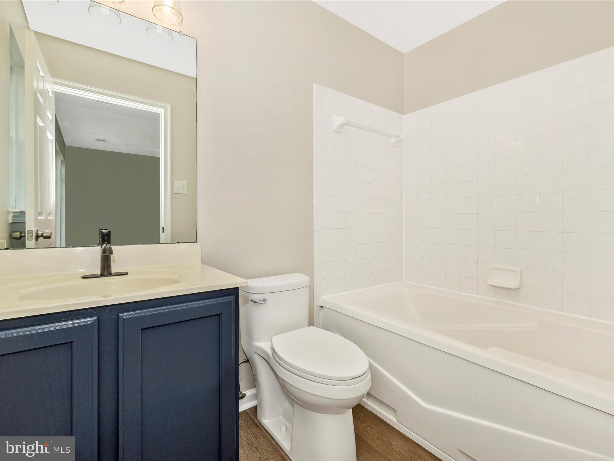5534 Upshur Square Frederick, MD 21703 - Photo 25 of 46 a bathroom with a granite countertop toilet a sink and bathtub