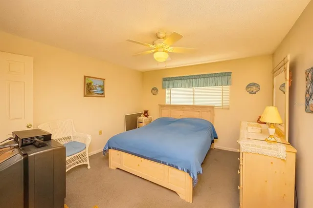 a bedroom with two beds and a ceiling fan