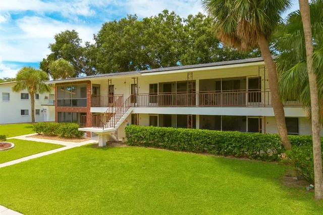 a view of a house with a yard and potted plants