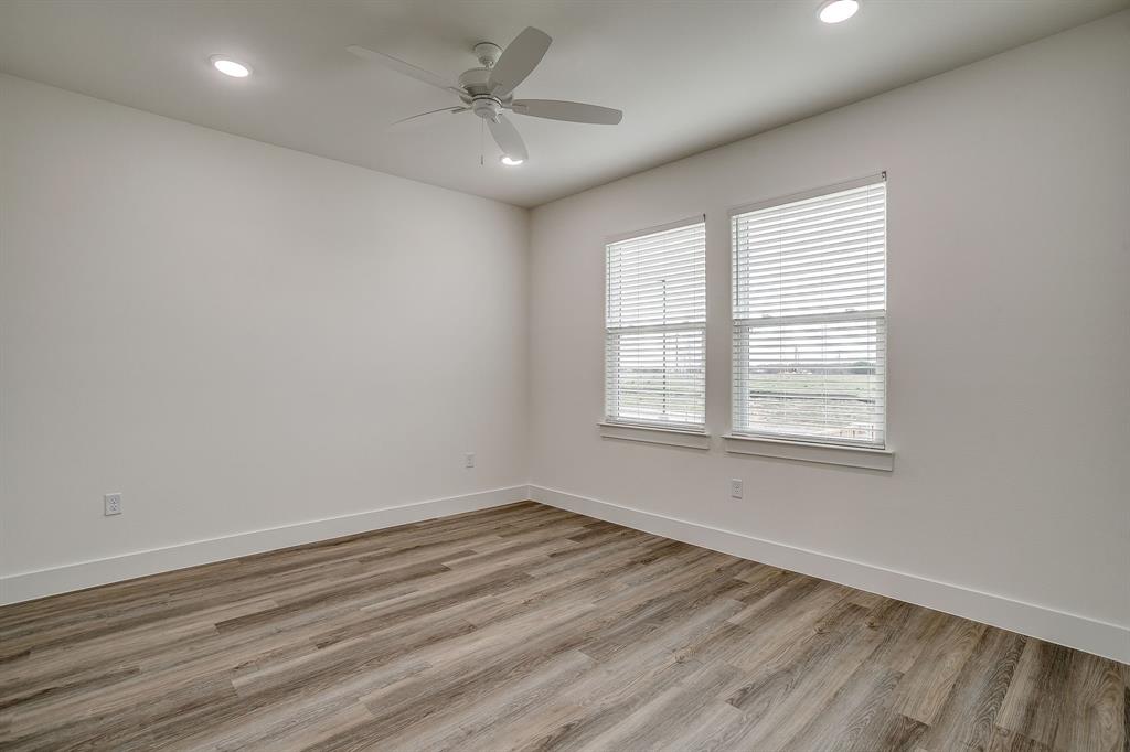100 Cardinal Wds Granbury, TX 76049 - Photo 27 of 32 an empty room with wooden floor fan and windows