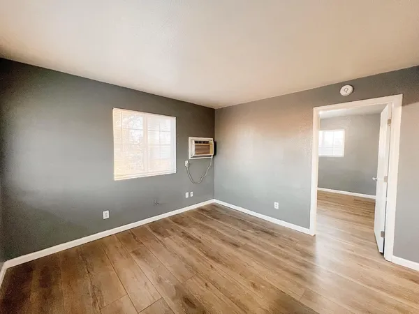 a view of empty room with wooden floor
