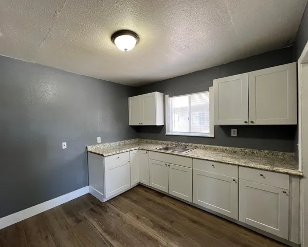 a kitchen with a sink cabinets and wooden floor