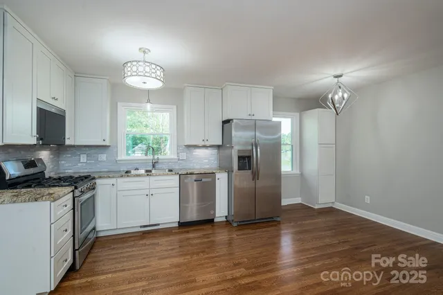 a kitchen with stainless steel appliances a refrigerator sink and microwave
