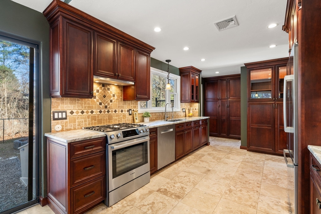 9 Mallard Drive Sharon, MA 02067 - Photo 8 of 32 a kitchen with stainless steel appliances granite countertop a stove a sink dishwasher a refrigerator and a oven with wooden cabinets