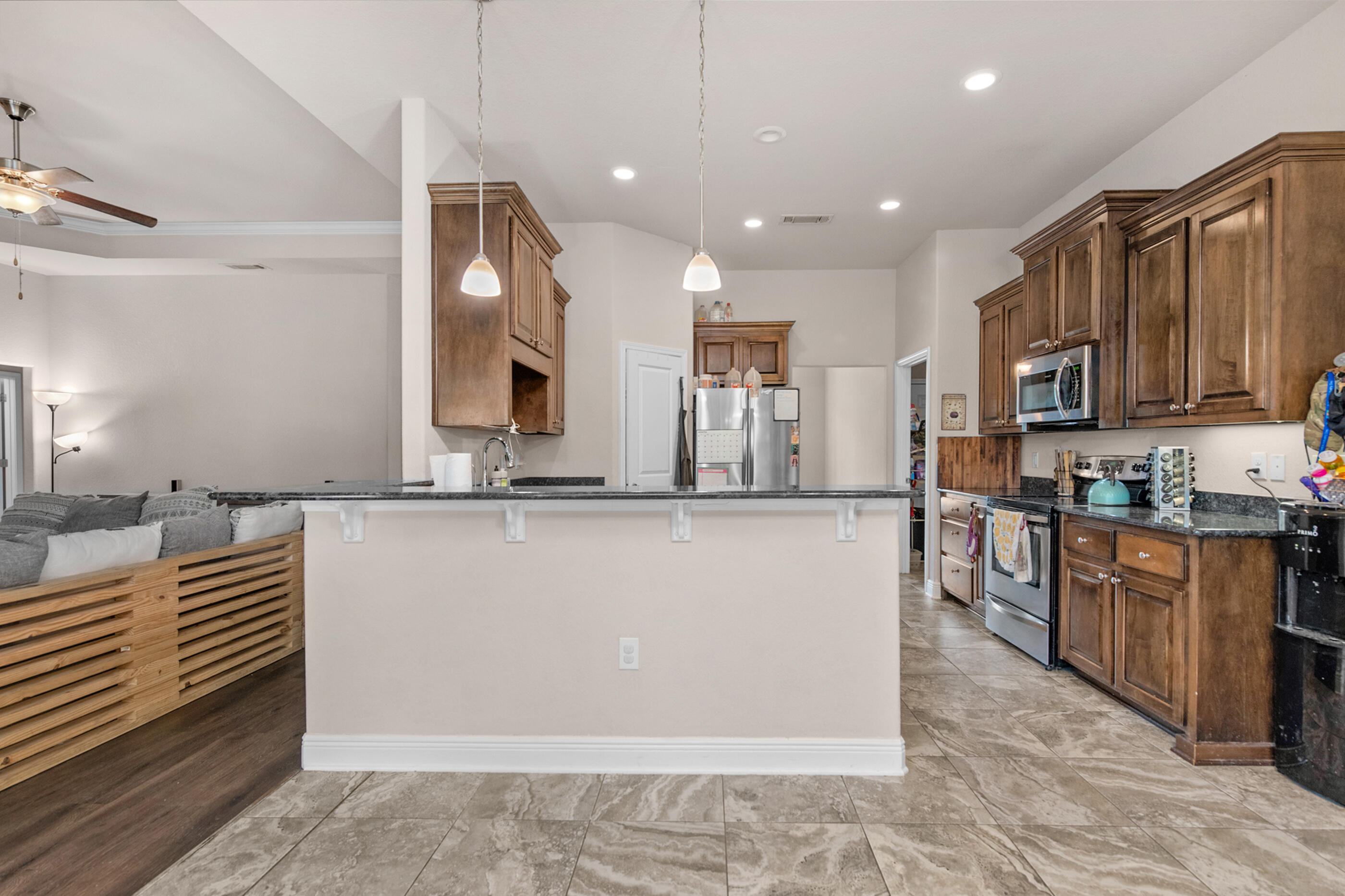 303 Vale Loop Crestview, FL 32536 - Photo 3 of 40 a large kitchen with stainless steel appliances granite countertop a stove a sink and a microwave