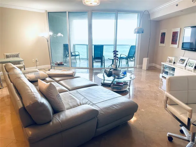 a living room with furniture flat screen tv and a large window