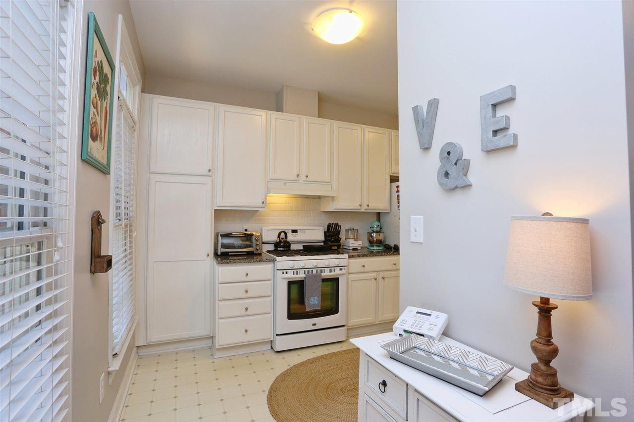 125 Fenner Lane Raleigh, NC 27603 - Photo 5 of 24 a kitchen with a stove a sink and a refrigerator