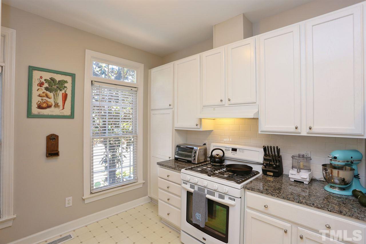 125 Fenner Lane Raleigh, NC 27603 - Photo 8 of 24 a kitchen with granite countertop white cabinets and white appliances