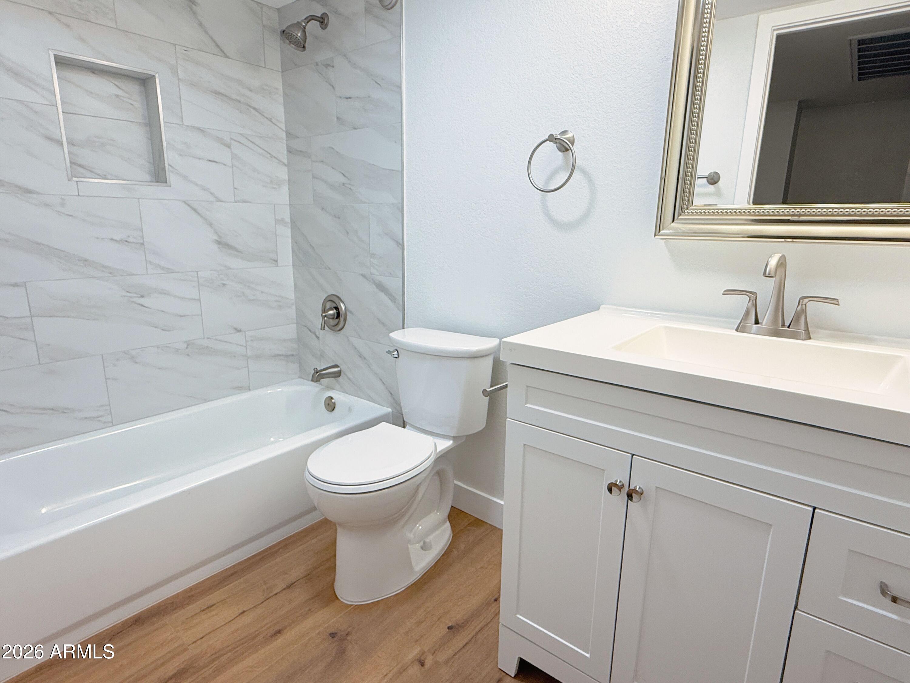18202 North Cave Creek Road, Unit 148 Phoenix, AZ 85032 - Photo 15 of 19 a bathroom with a toilet sink vanity tub and shower