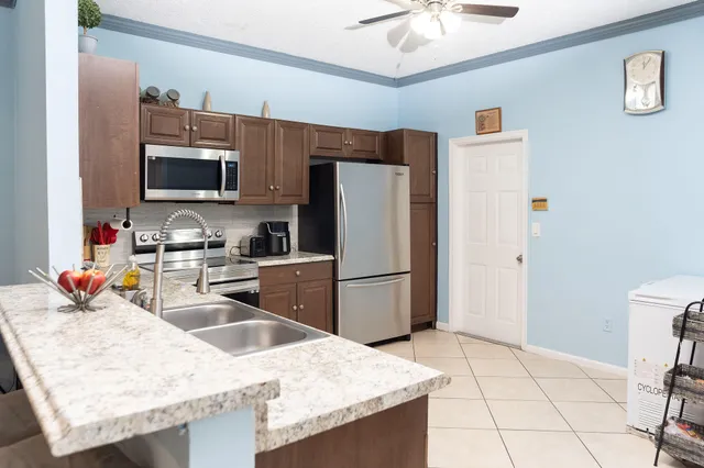 a kitchen with stainless steel appliances granite countertop a sink refrigerator and microwave