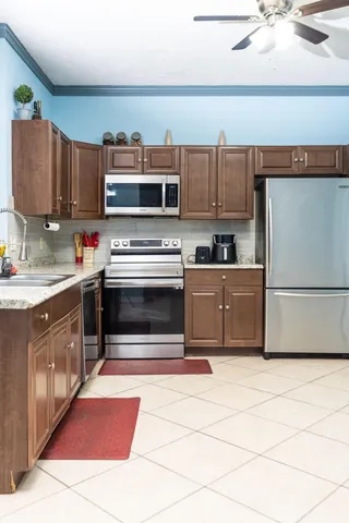 a living room with a table chairs and a refrigerator