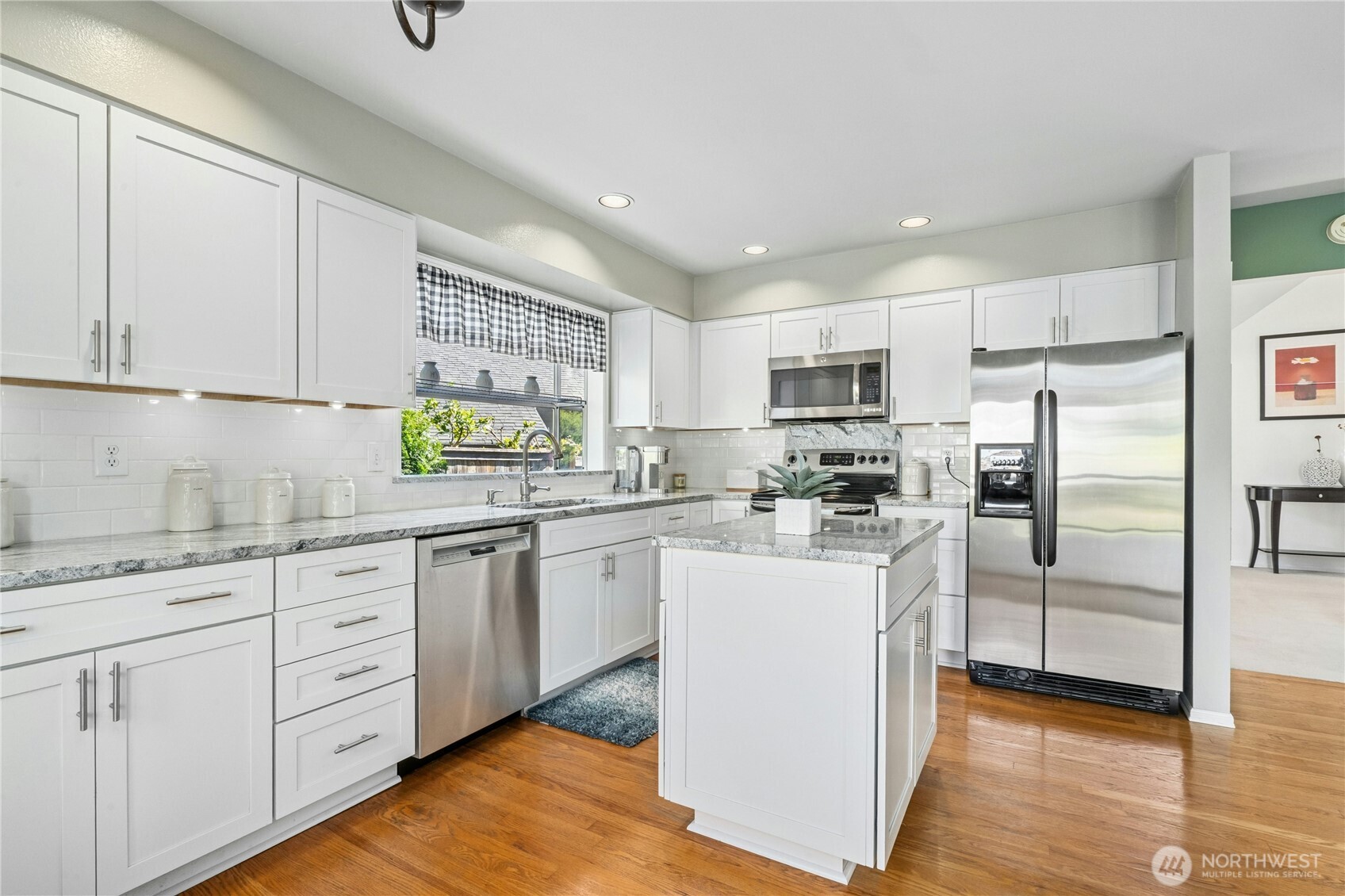 12818 Northeast 203rd Place Bothell, WA 98011 - Photo 10 of 36 a kitchen with white cabinets and stainless steel appliances