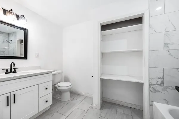 a bathroom with a sink a toilet and a mirror