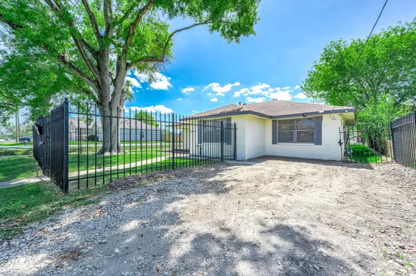 a view of a house with a backyard and a tree