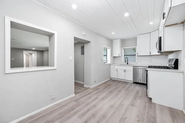 a kitchen with stainless steel appliances granite countertop a sink a stove and microwave
