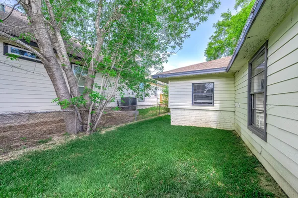 a backyard of a house with large trees and barbeque oven