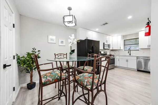 a view of a dining room with furniture a chandelier and wooden floor