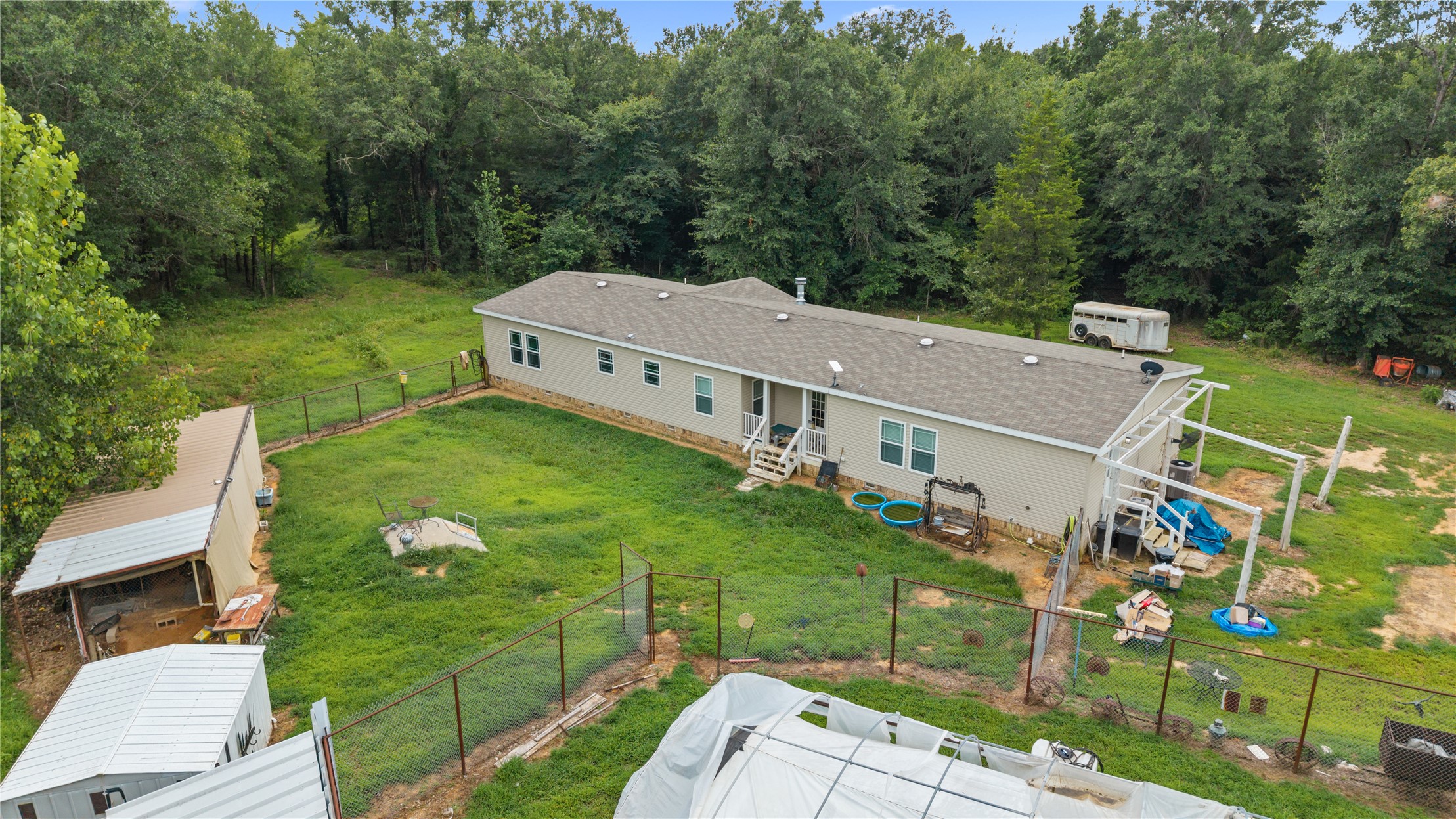 1800 2110th Road Hugo, OK 74743 - Photo 26 of 27 Expansive property featuring a single-story residence with a covered porch, multiple outbuildings, and extensive fencing