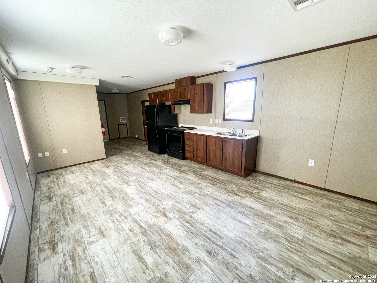 18234 Benton City Road Von Ormy, TX 78073 - Photo 16 of 25 a view of a kitchen with furniture and wooden floor