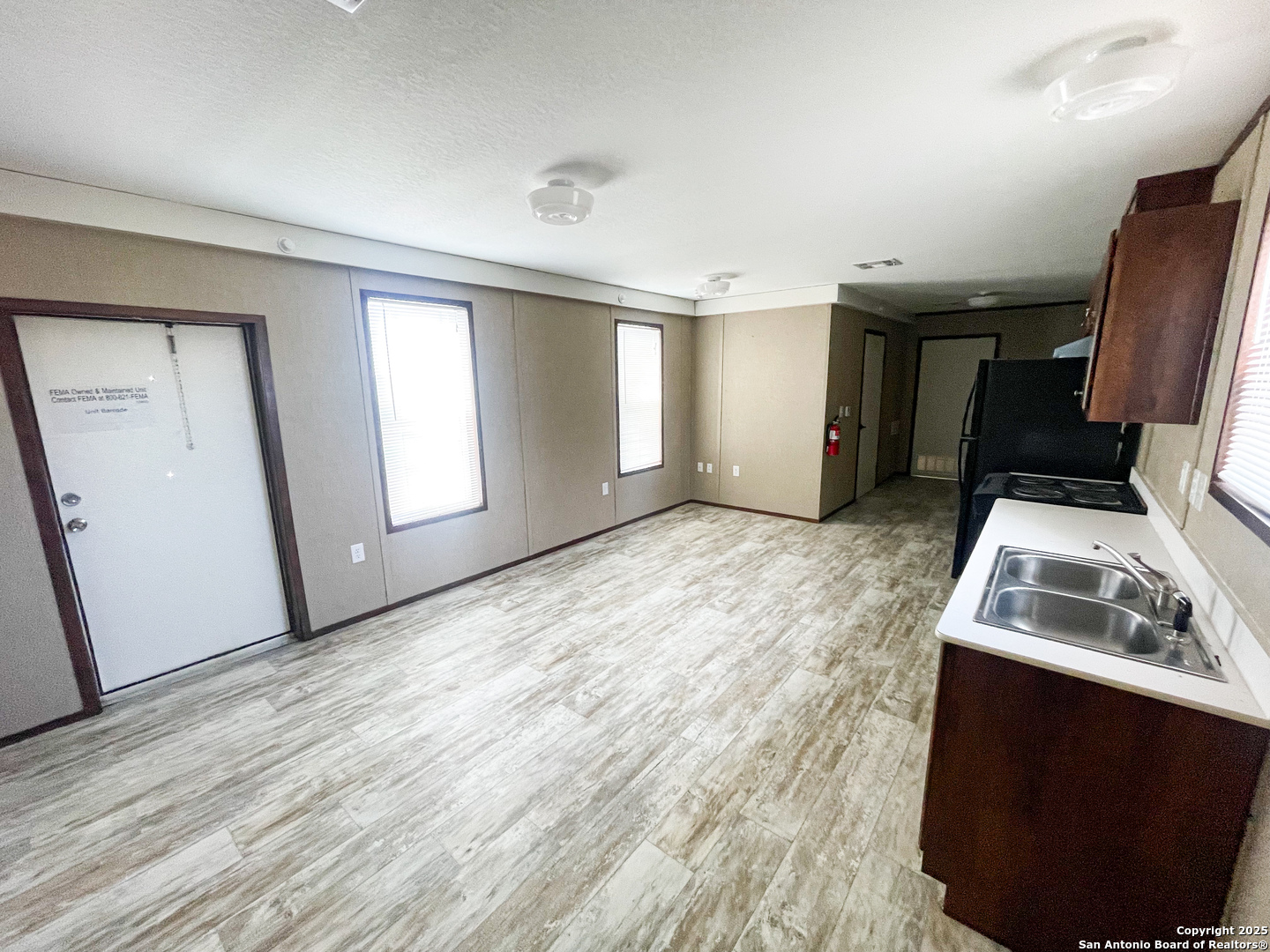 18234 Benton City Road Von Ormy, TX 78073 - Photo 17 of 25 a view of empty room with wooden floor and fan