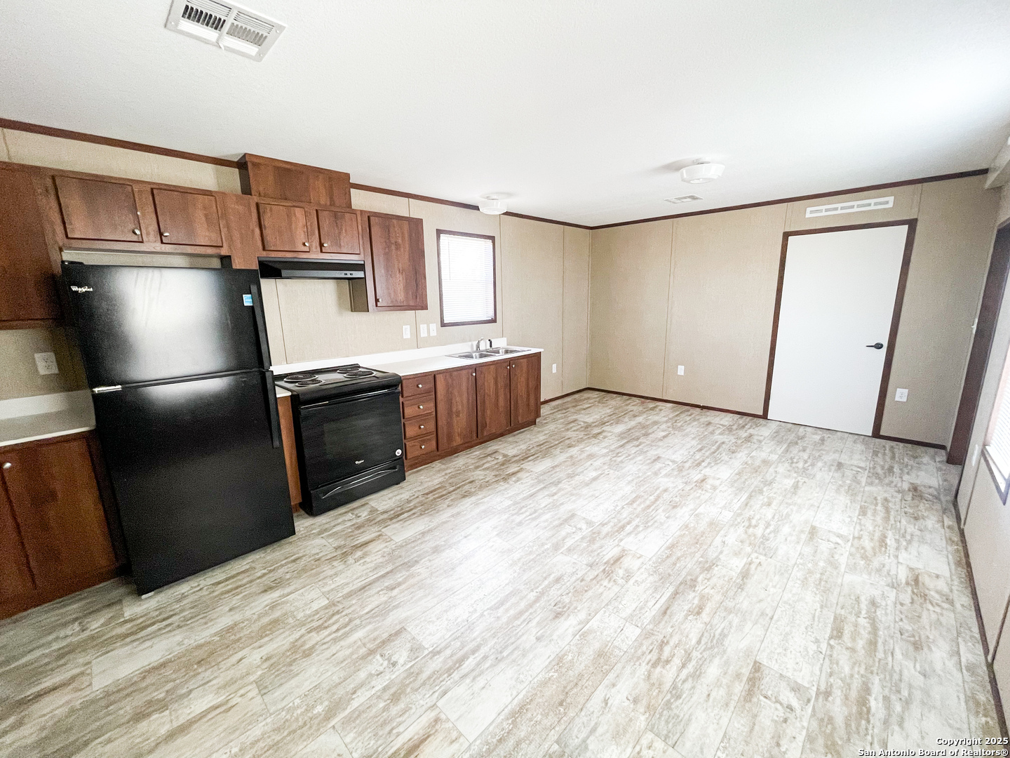 18234 Benton City Road Von Ormy, TX 78073 - Photo 18 of 25 a kitchen with granite countertop a refrigerator and a sink