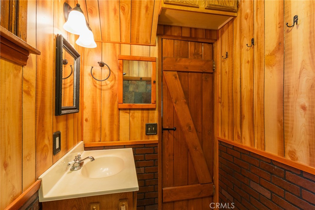 26370 Alpine Lane Twin Peaks, CA 92391 - Photo 22 of 37 a bathroom with a sink a mirror and a shower
