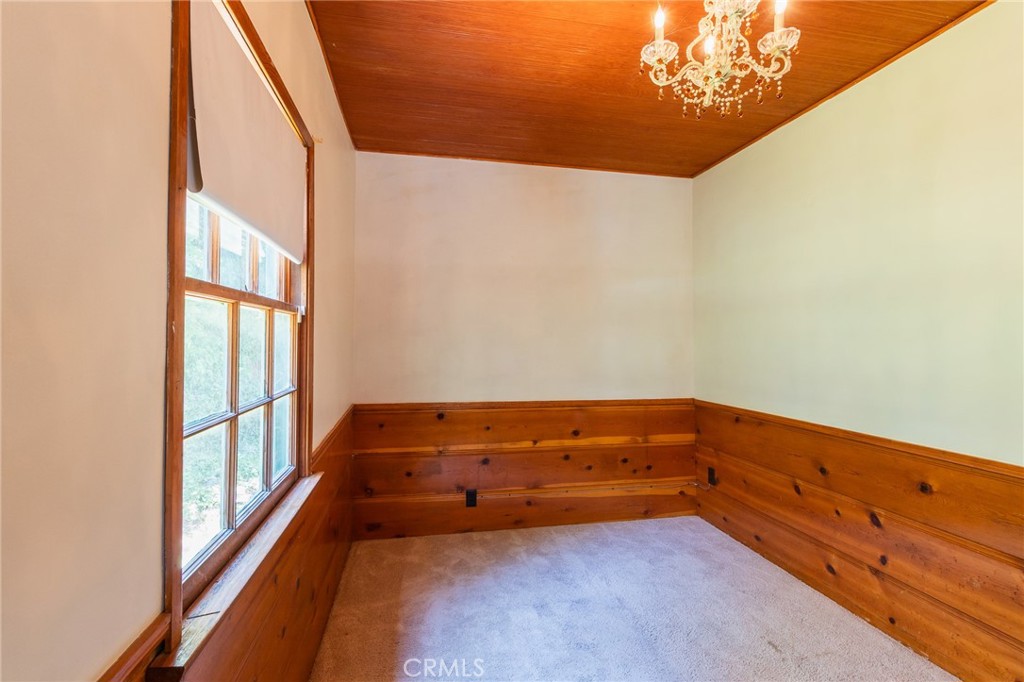 26370 Alpine Lane Twin Peaks, CA 92391 - Photo 24 of 37 a room with a dresser and a chandelier