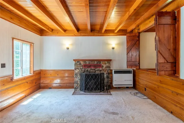 a view of an empty room with a fireplace and a window