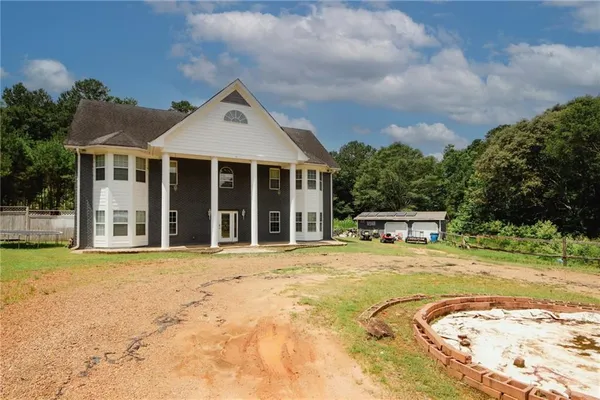 a view of a house with pool and chairs
