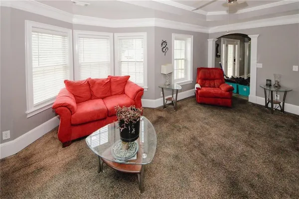 a living room with furniture a window and a flat screen tv