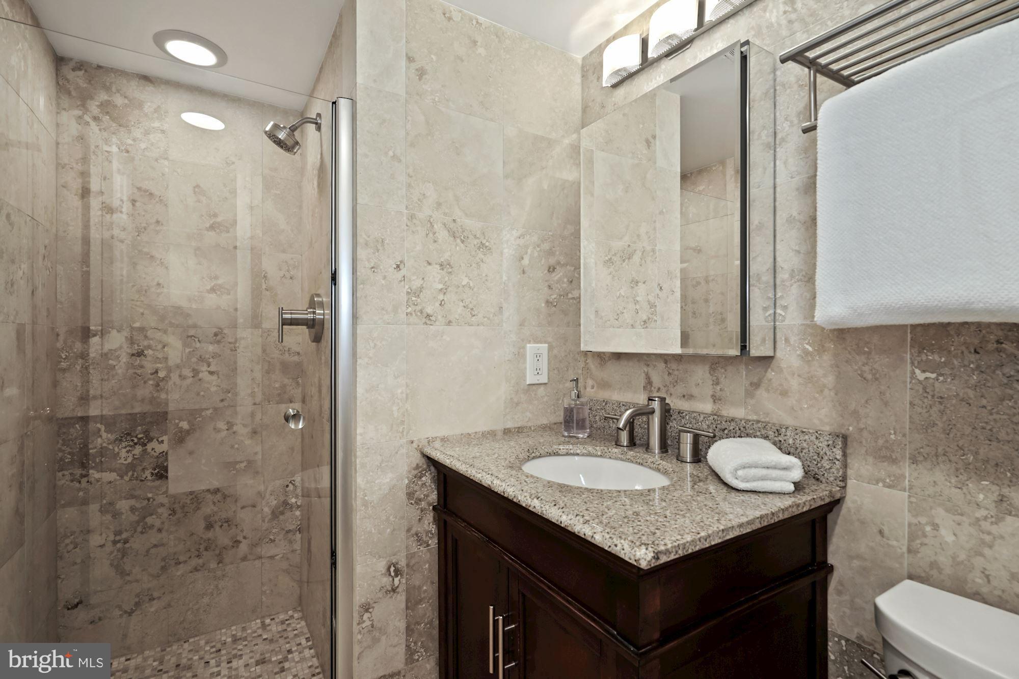 1301 North Courthouse Road, Unit 801 Arlington, VA 22201 - Photo 18 of 31 Travertine owner's bath w/walk-in shower