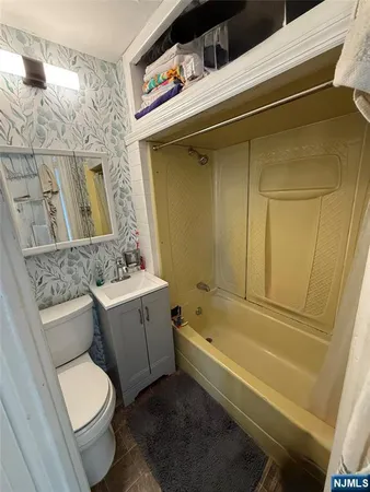 a bathroom with a granite countertop toilet sink and mirror
