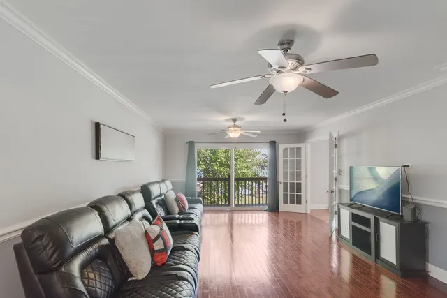a living room with furniture ceiling fan and a window