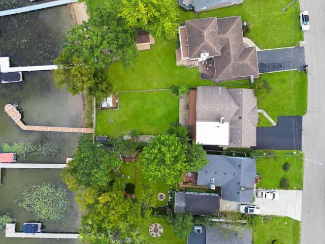 an aerial view of a house with outdoor space and a lake view