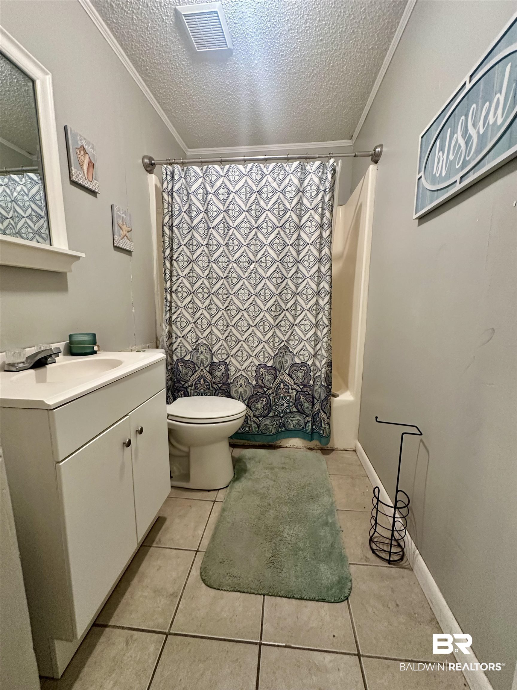 3451 Kirkland Road Brewton, AL 36426 - Photo 14 of 17 Full bathroom with a textured ceiling, shower / bath combo, crown molding, and tile patterned floors