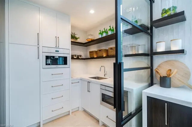 a kitchen with white cabinets and appliances